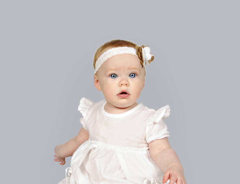 Beautiful little baby girl in a white dress